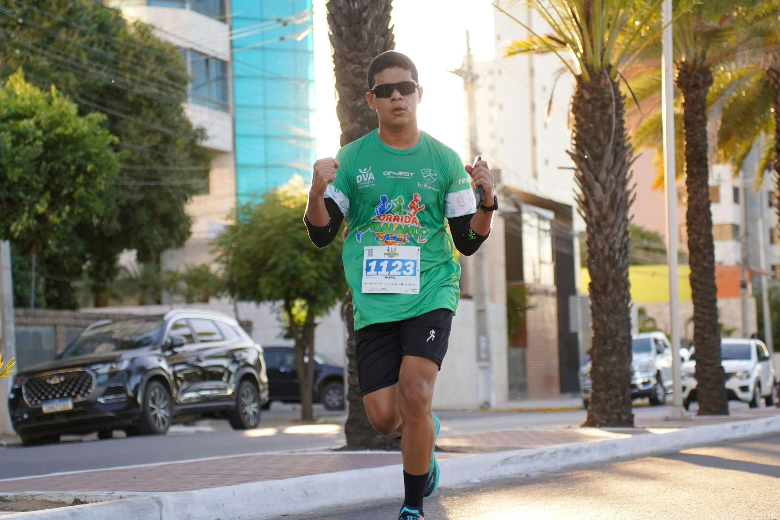 Male runner in a city marathon during the day, showing determination.