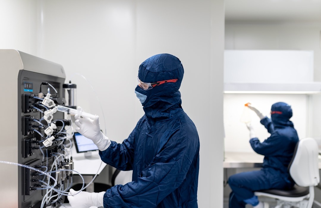 Laboratory technicians working in the lab | a few people in protective gear working on a computer
