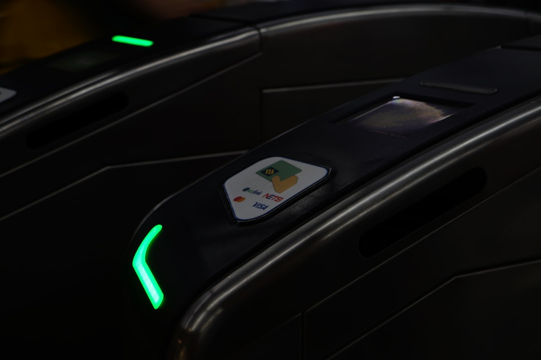 A mass rapid transit (MRT) gate that accepts contactless cards, digital wallets, EZ-Link cards and NETS cards. | a close up of a black electronic device
