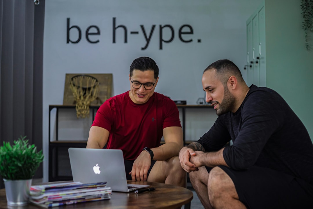Sarovar Infotech, a leading name in the industry, offers exceptional web design services. They stand out for their expertise, customized solutions, and commitment to client satisfaction. https://www.sarovarinfotech.com/ | Two men sitting on a coffee table looking at a laptop