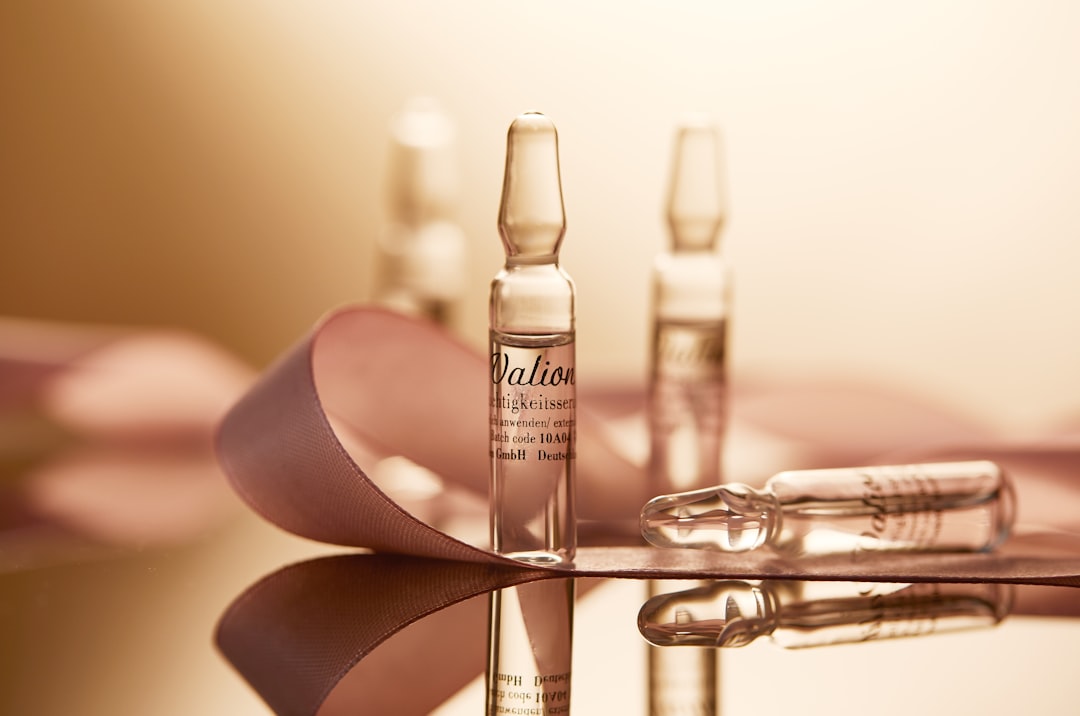 Injection Cosmetics | a table topped with bottles of liquid next to a pair of scissors