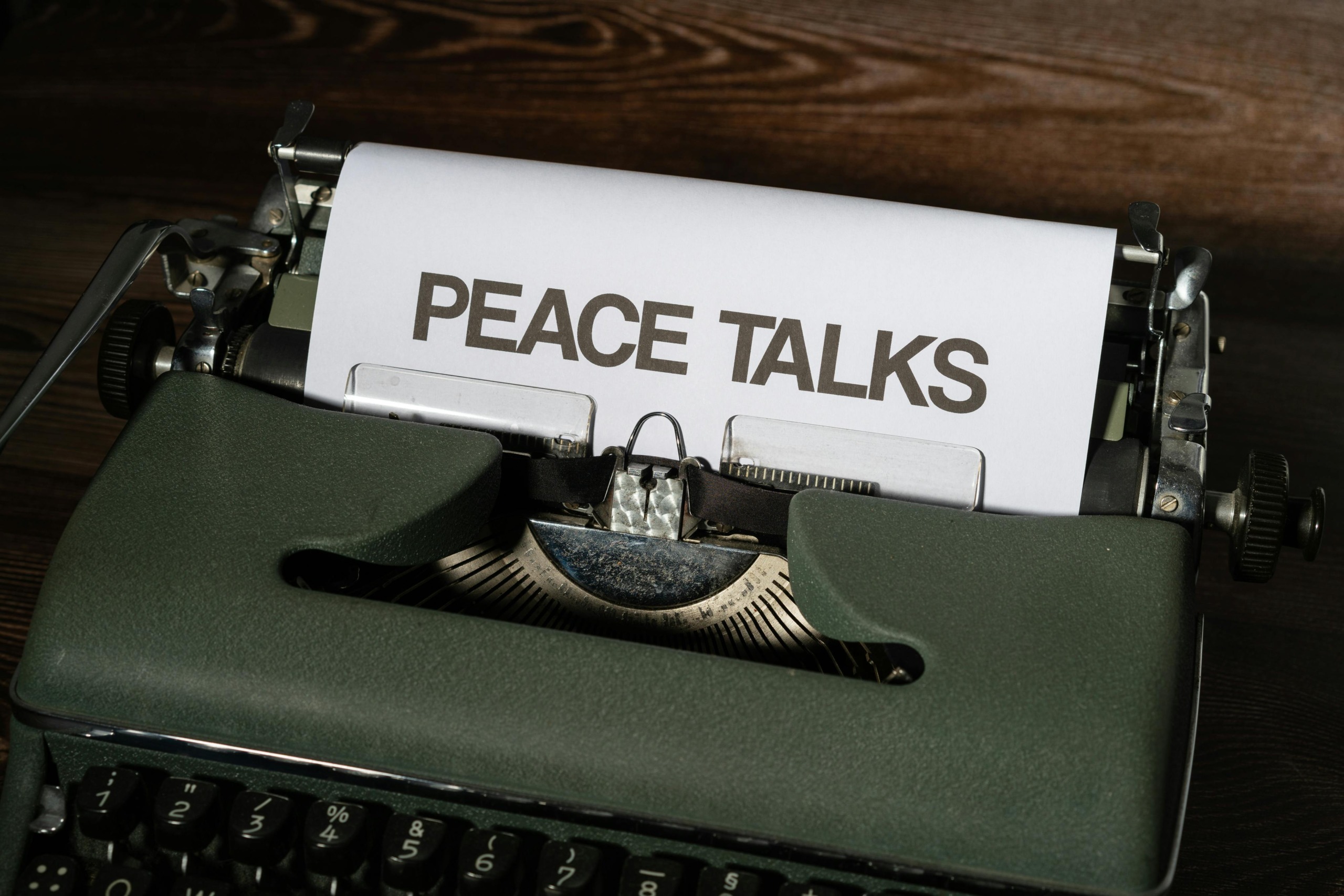 A classic typewriter displays the words 'Peace Talks', symbolizing communication and diplomacy.